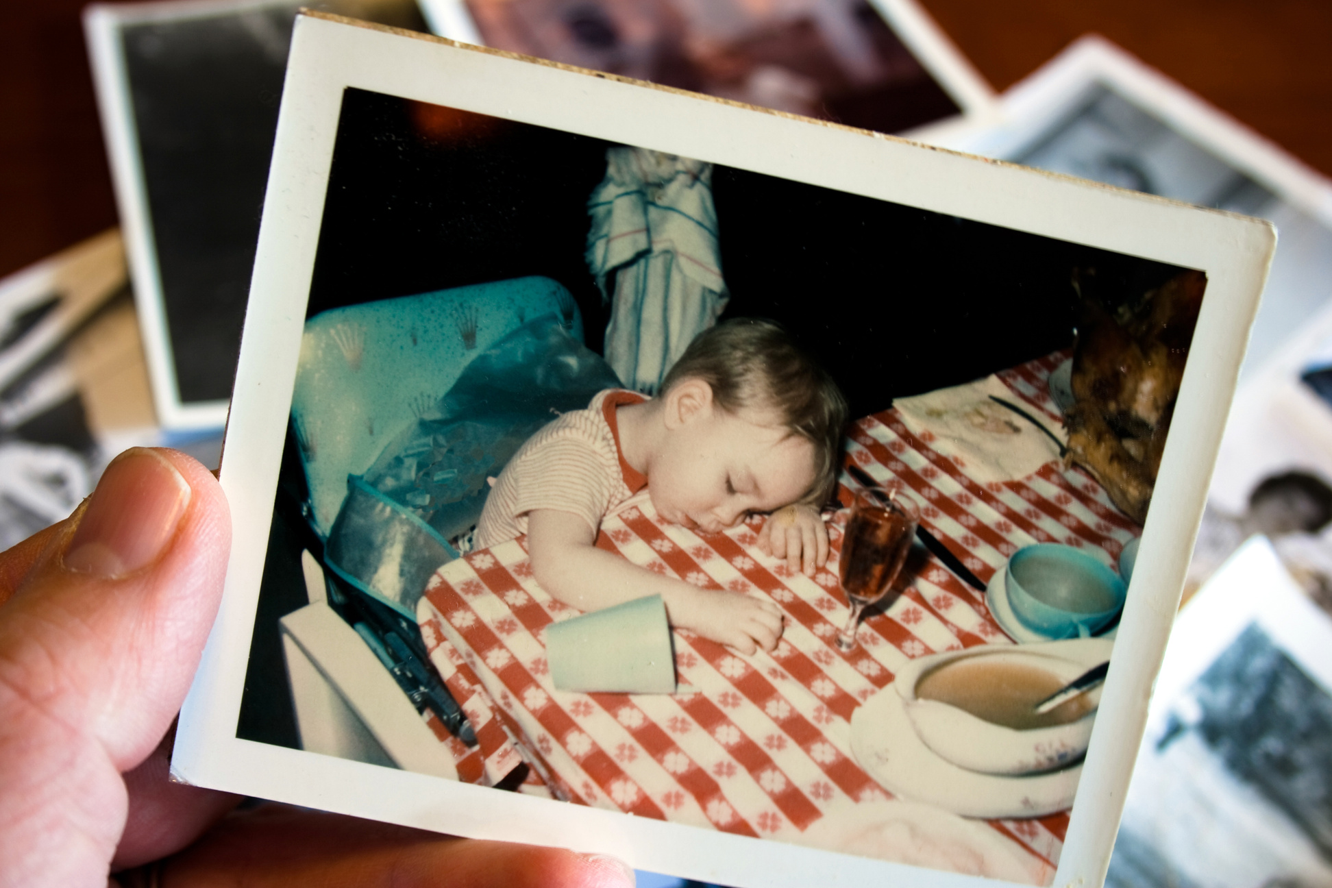Hand holds Vintage photograph of boy at thanksgiving